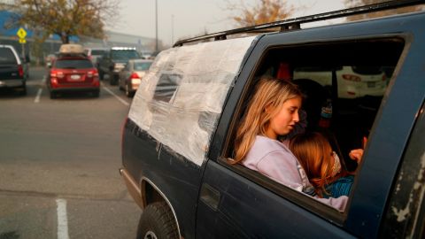 Dakota Keltner, right, rests on Havyn Cargill-Morris in a truck at the tent city outside a Walmart store in Chico.