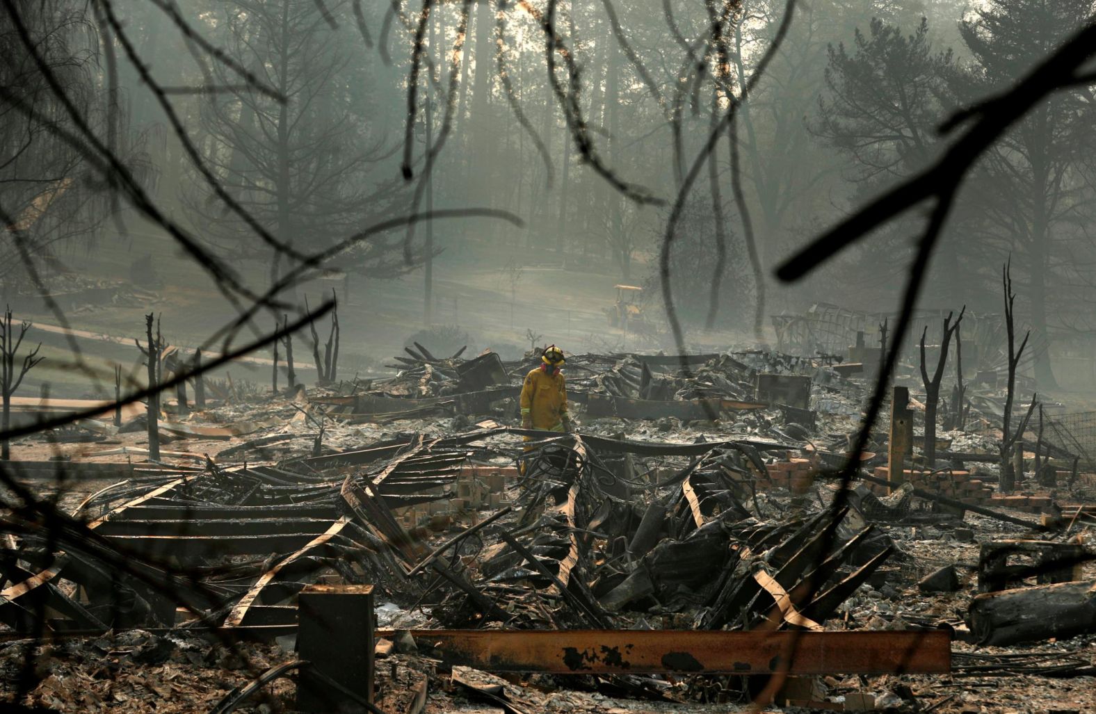 A firefighter searches for human remains on Friday, November 16, in a Paradise trailer park destroyed in the Camp Fire.
