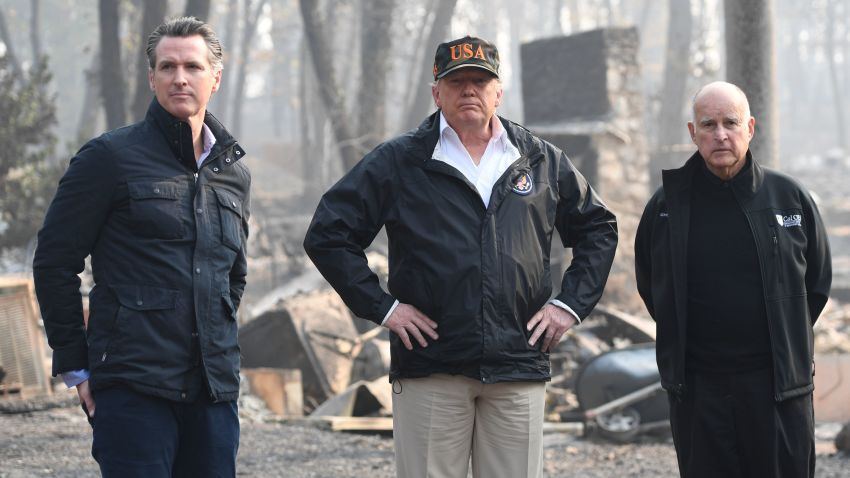 US President Donald Trump (C) looks on with Governor of California Jerry Brown (R) and Lieutenant Governor of California, Gavin Newsom, as they view damage from wildfires in Paradise, California on November 17, 2018. - President Donald Trump arrived in California to meet with officials, victims and the "unbelievably brave" firefighters there, as more than 1,000 people remain listed as missing in the worst-ever wildfire to hit the US state. (Photo by SAUL LOEB / AFP)        (Photo credit should read SAUL LOEB/AFP/Getty Images)