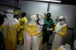 Health workers embrace before heading into the red zone at an Ebola treatment center in Bunia, DRC in 2018.