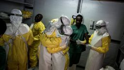 Health workers embrace whilst putting on their personal protective equipment (PPE) before heading into the red zone at a newly build MSF (Doctors Without Borders) supported ebola treatment centre (ETC) on November 7, 2018 in Bunia, Democratic Republic of the Congo. - The death toll from an Ebola outbreak in eastern Democratic Republic of Congo has risen to more than 200, the health ministry said on November 10, 2018. (Photo by John WESSELS / AFP)        (Photo credit should read JOHN WESSELS/AFP/Getty Images)