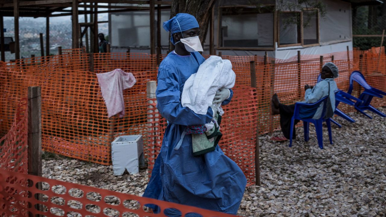 A health worker carries a four-day-old baby suspected of having Ebola in the city of Butembo.