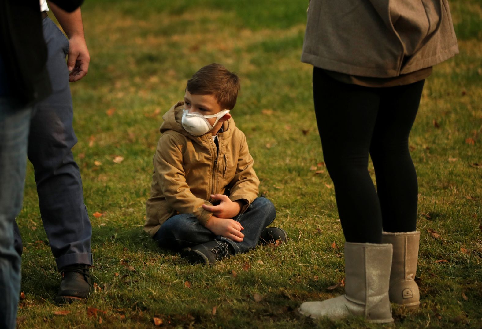 A child wears a smoke mask while watching President Trump''s motorcade in Chico on November 17.