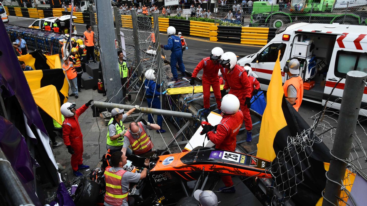 Race personnel and pit crew are seen at the accident site after Sophia Floersch flew over the barriers and crashed into a fence during a Formula Three race at the Macau Grand Prix.