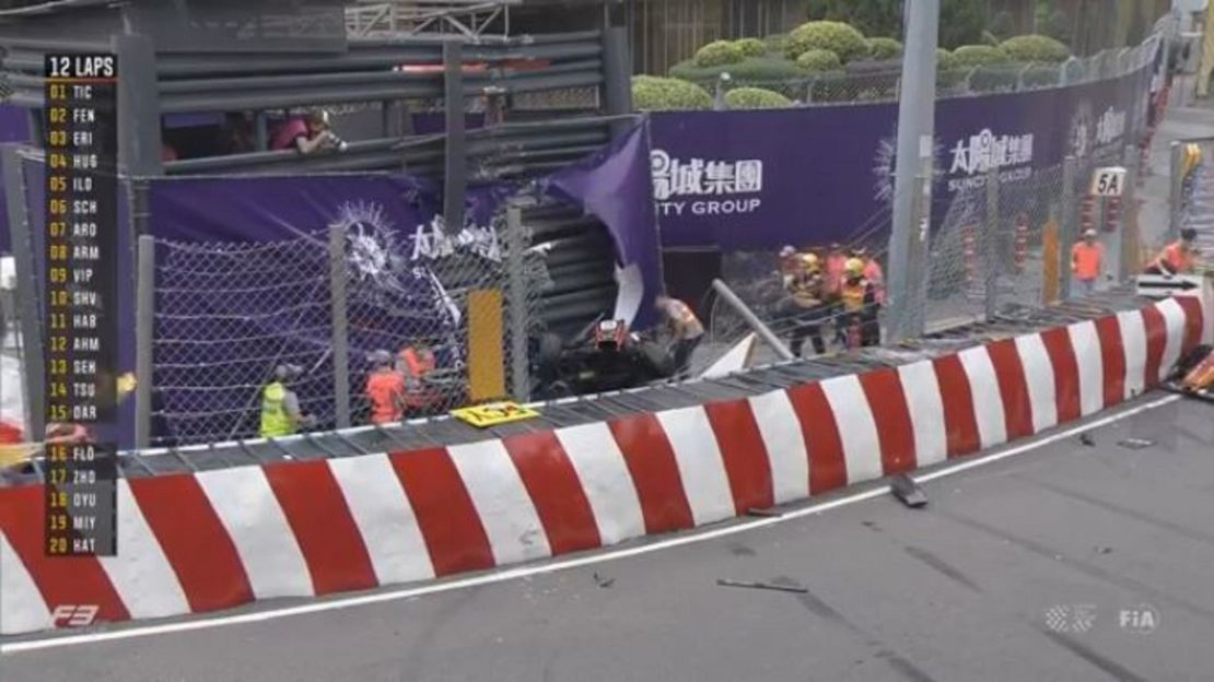 Race personnel and pit crew are seen at the accident site after Sophia Floersch flew over the barriers and crashed into a photographers' bunker.