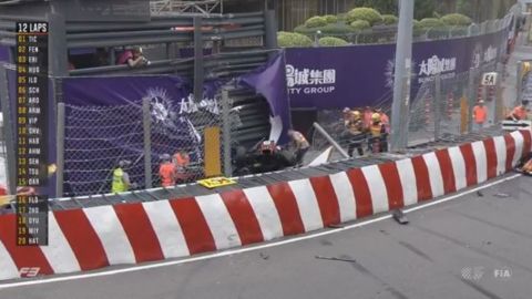 Race personnel and pit crew are seen at the accident site after Sophia Floersch flew over the barriers and crashed into a photographers' bunker.