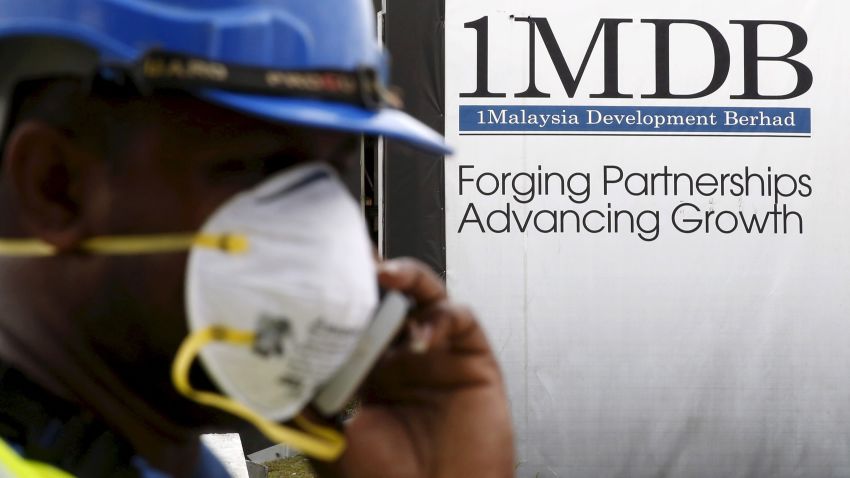 A construction worker talks on the phone in front of a 1Malaysia Development Berhad (1MDB) billboard at the Tun Razak Exchange development in Kuala Lumpur, Malaysia, February 3, 2016.   REUTERS/Olivia Harris/File Photo