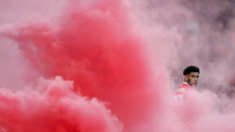 Wales' Tyler Roberts is surrounded by smoke after fans threw a flare onto the pitch during a soccer match between Wales and Denmark on November 16 in Cardiff, United Kingdom.
