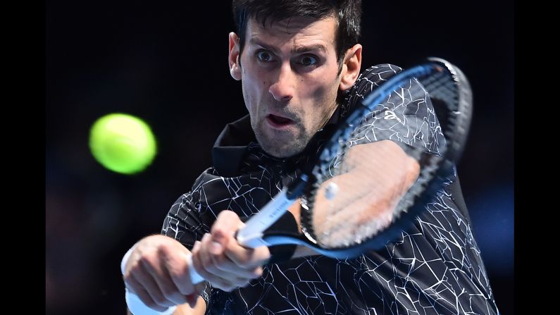 Novak Djokovic returns the ball against John Isner during their men's singles round-robin match on day two of the ATP World Tour Finals tennis tournament at the O2 Arena in London on November 12.