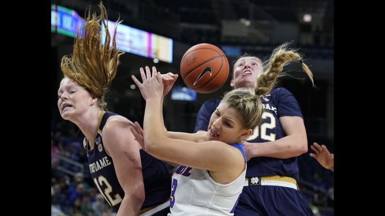 DePaul's Dee Bekelja fights for a rebound between Notre Dame players Abby Prohaska, left, and Jessica Shepard, right, during the second half of an NCAA college basketball game on November 17 in Chicago, Illinois.