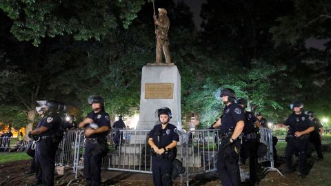 Police wearing riot gear guard a statue of a Confederate soldier nicknamed Silent Sam on the campus of the University of North Carolina. 