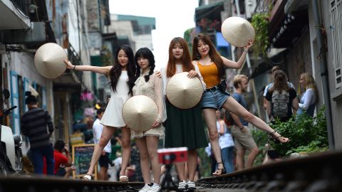 Tourists pose on Hanoi's "train street"  prior to its closure. 