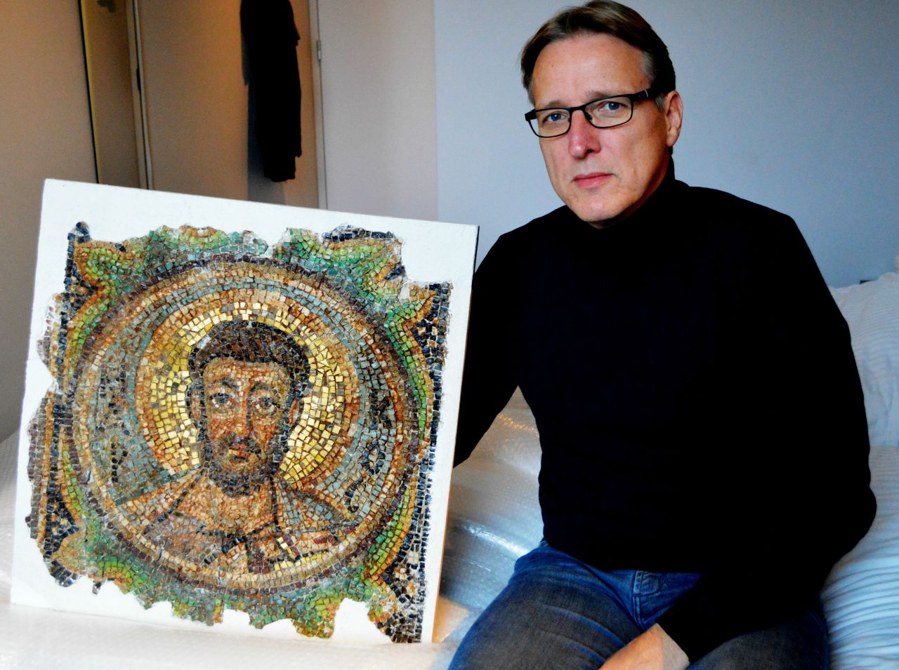 Dutch art detective Arthur Brand poses with the missing mosaic of St. Mark, a rare piece of stolen Byzantine art from Cyprus.