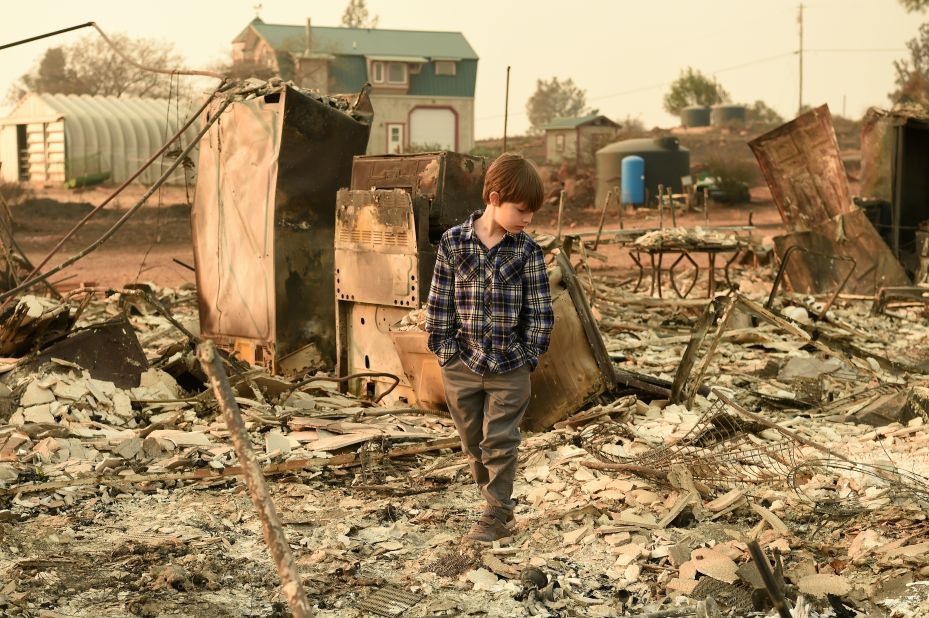 Jacob Saylors, 11, walks through the burned remains of his home in Paradise, California, on Sunday, November 18. His family lost a home in the same spot to a fire 10 years earlier. 