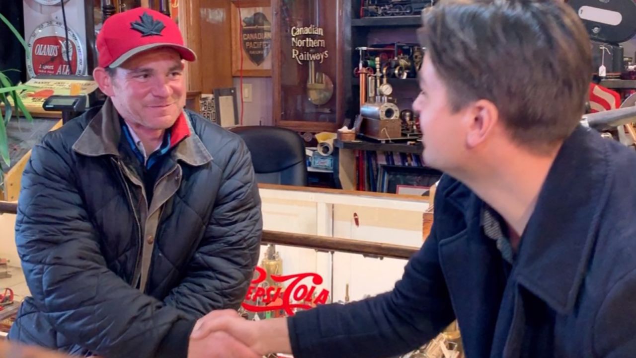 Adam Gillian, left, shakes hands with antique dealer Alexander Archbold.