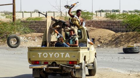 Pro-government forces cheer in the back of a pickup mounted with a machine gun outside Hodeidah.