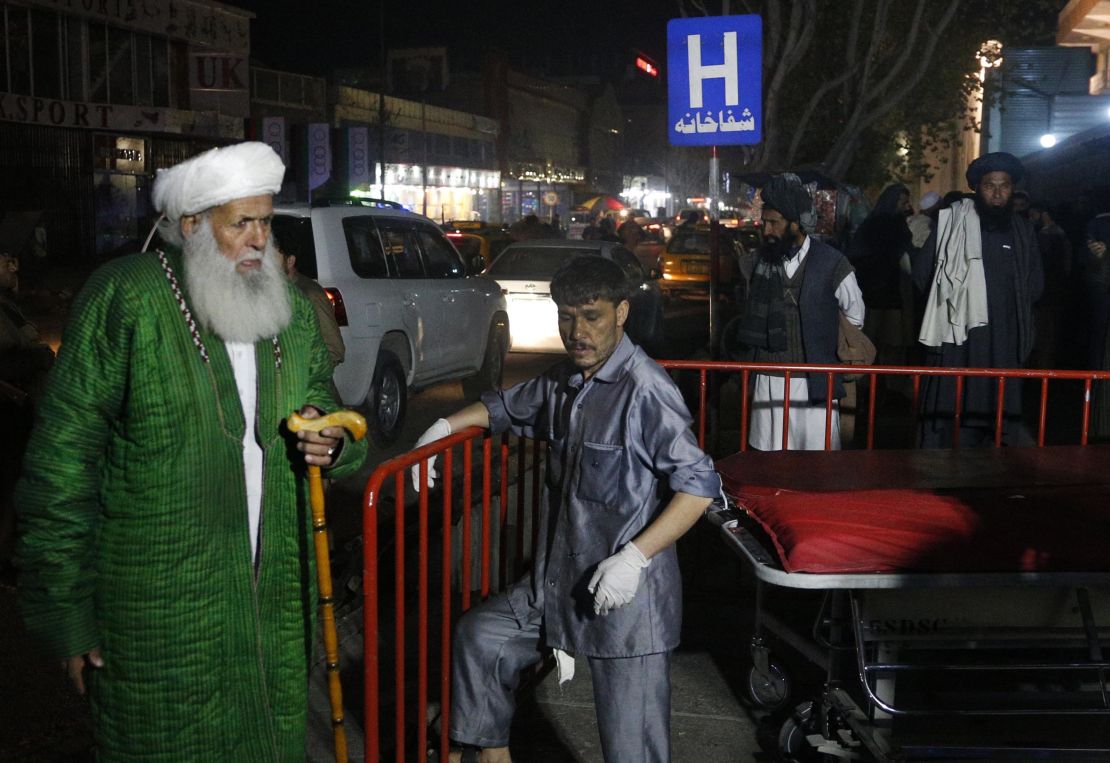 Afghan religious scholars wait outside the hospital after a suicide bomber targeted a gathering.