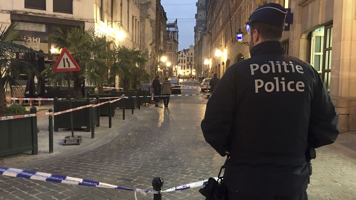 A police officer stands behind a police tape during investigations at a stabbing scene in the center of Brussels on Tuesday.