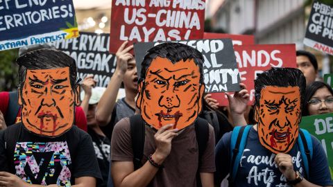 Protesters holds caricatures of Xi Jinping during a protest in Manila.
