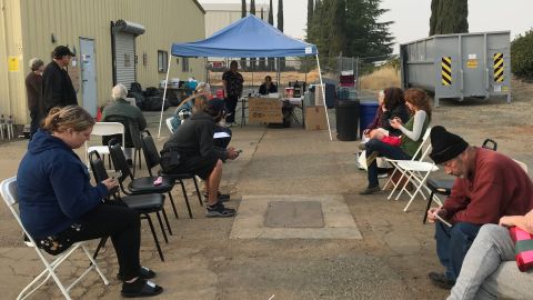 People waiting outside an animal shelter at the Chico airport on Tuesday to see if they can find their pet out of the hundreds housed there.