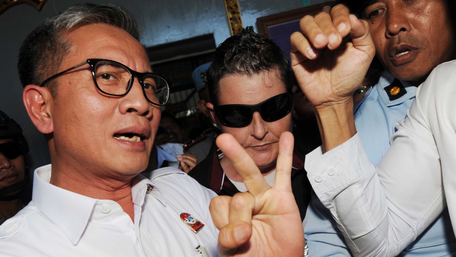 Renae Lawrence (center, wearing sunglasses) is escorted from prison in Bali on Wednesday after serving 13 years.