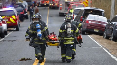 Firefighters carry a stretcher to the scene of a fatal fire at 15 Willow Brook Rd. on Tuesday in Colts Neck.