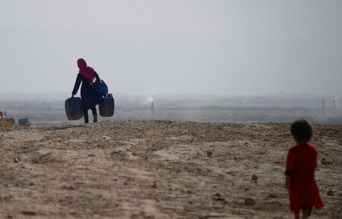 A girl carries empty containers to collect water in Sakhi village on the outskirts of Mazar-i-Sharif, in northern Afghanistan, on July 19. 