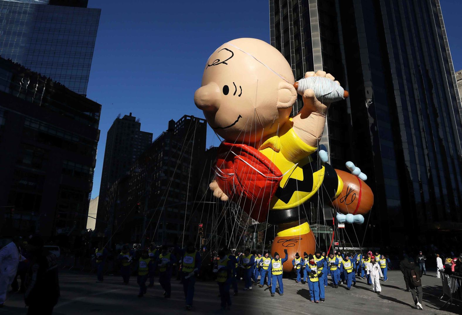 A Charlie Brown float glides past skyscrapers.