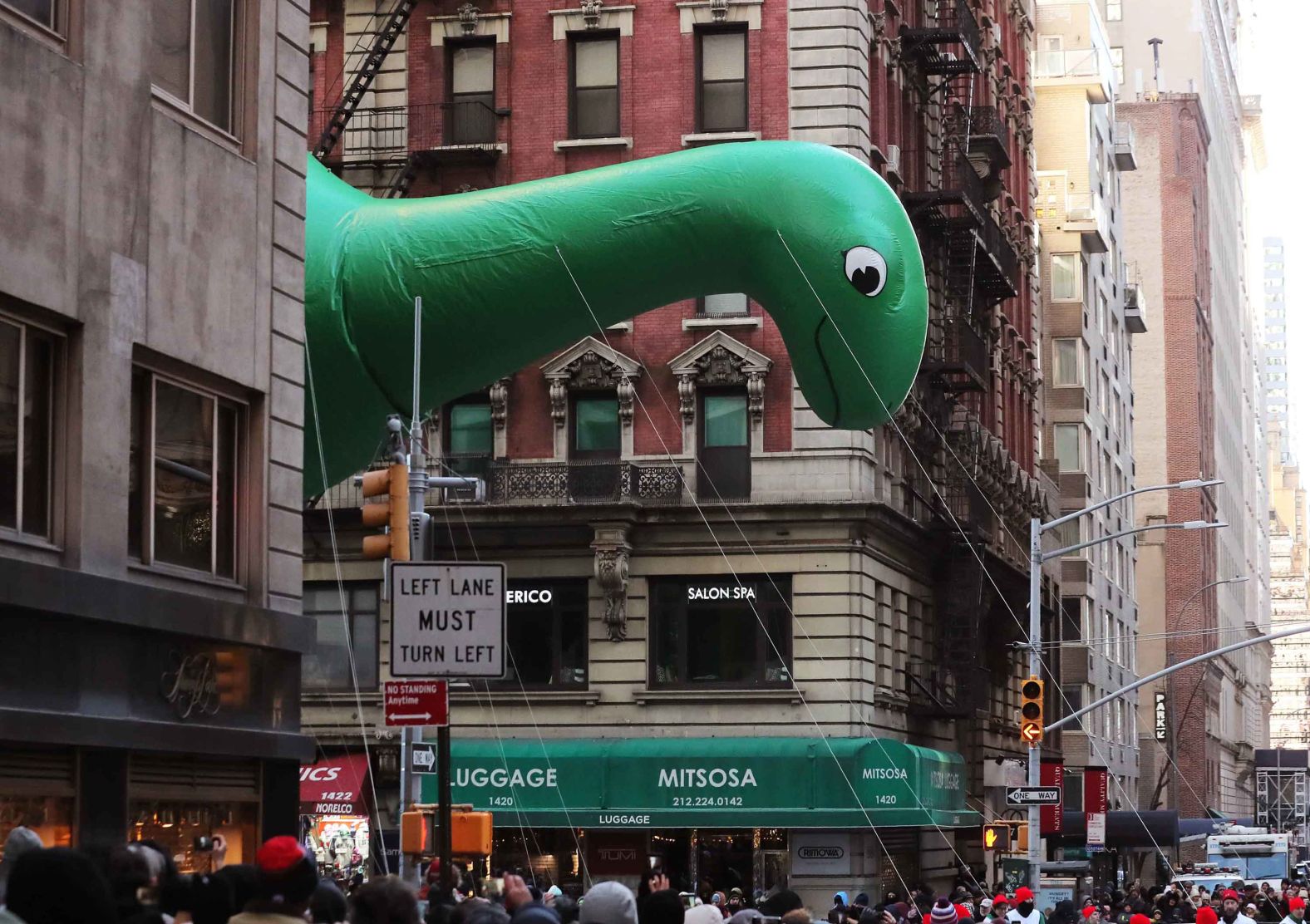 The Sinclair dinosaur hovers above the crowd.