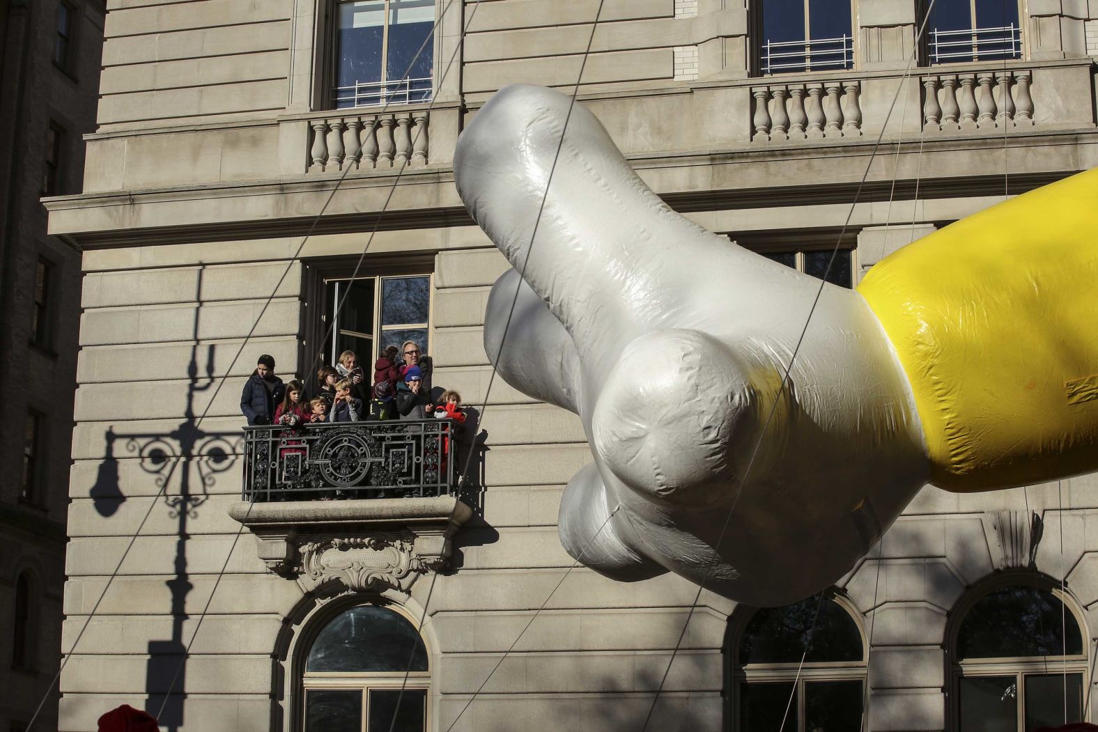 People watch the parade from a balcony.