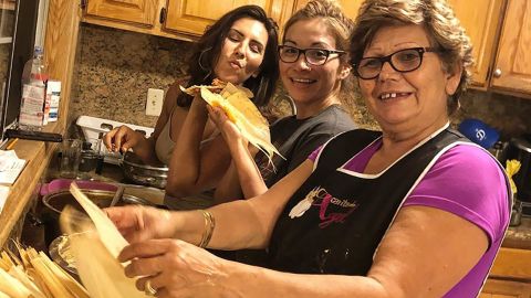 Elizabet Gomez, left, prepares corn husks for tamales with her sister and mother.