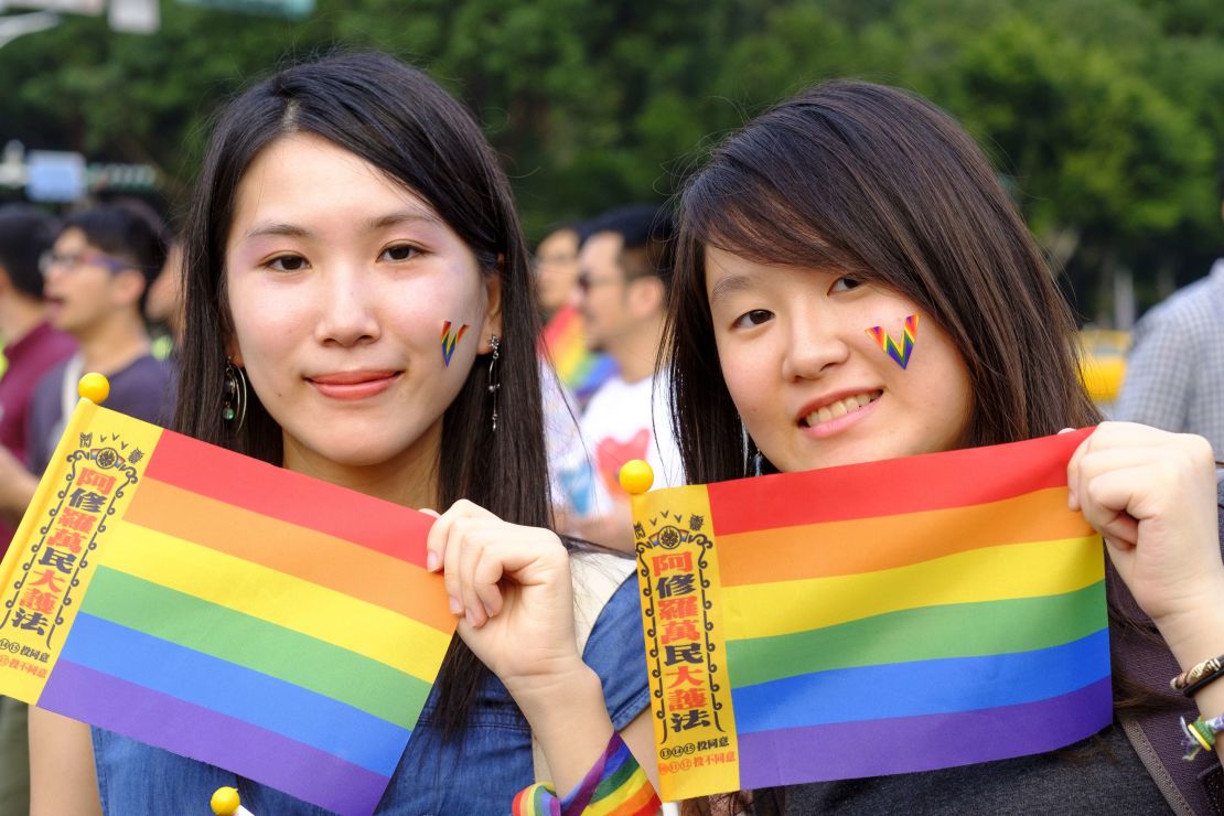 Two young women hold rainbow flags in support of same sex marriage during a gay pride parade in Taipei October, 2018.