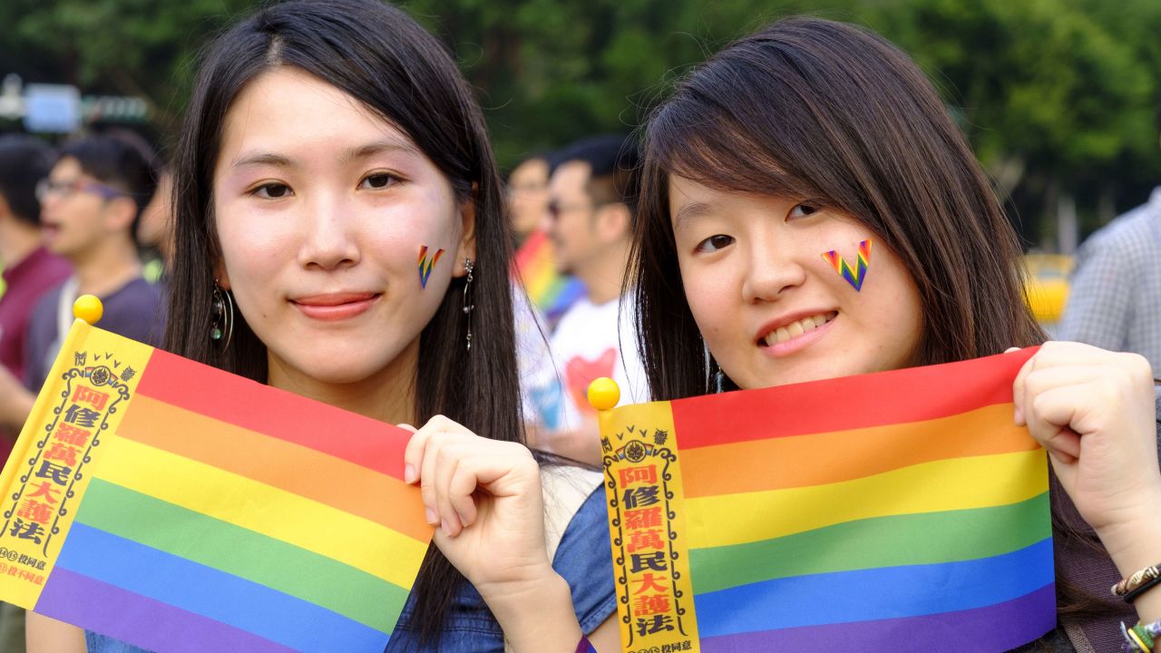 Two young women hold rainbow flags in support of same sex marriage during a gay pride parade in Taipei October, 2018.