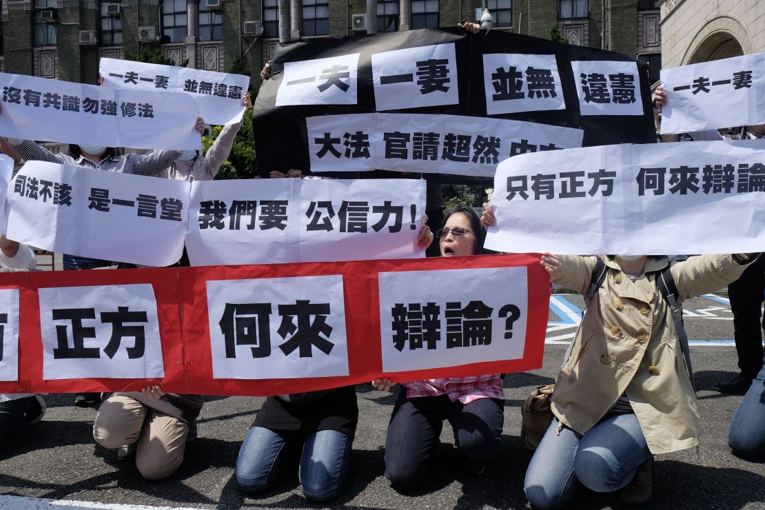 Conservative activists display signs reading "one husband, one wife does not go against the constitution" in Taipei, on March 24, 2017.