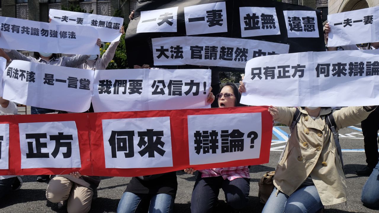 Conservative activists display signs reading "one husband, one wife does not go against the constitution" in Taipei, on March 24, 2017.