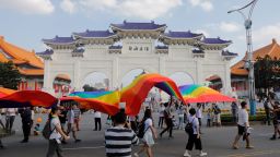 Participants walk with a rainbow banner past the Chiang Kai-shek Memorial Hall during a gay pride parade in Taipei on October 27, 2018.