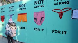 A pedestrian walks past a mural showing pictures of underwear with the slogan 'Not Asking For It' in a street in Dublin on November 17, 2018 as a protest after a defence lawyer showed a 17-year-old girl's thong or G-string in court as alleged proof of her consent in a rape case. - Protests have flared across Ireland this week triggering a viral campaign online after a defence lawyer showed a 17-year-old girl's thong or G-string in court as alleged proof of her consent in a rape case. The outrage has included a female lawmaker brandishing underwear in parliament and women posting pictures of their thongs online with the hashtag #ThisIsNotConsent. (Photo by Paul FAITH / AFP)        (Photo credit should read PAUL FAITH/AFP/Getty Images)