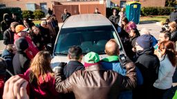 Demonstrators surround a government vehicle after Samuel Oliver-Bruno, 47, an undocumented Mexican national, was arrested after arriving at an appointment with immigration officials, Friday, Nov. 23, 2018, in Morrisville, N.C. He has been living in CityWell United Methodist Church in Durham since late 2017 to avoid the reach of immigration officers, who generally avoid making arrests at churches.  (Travis Long/The News & Observer via AP)