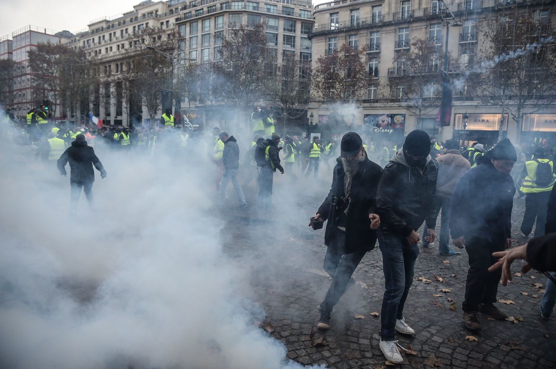 Protesters clash with riot police who fired tear gas canisters Saturday in central Paris.