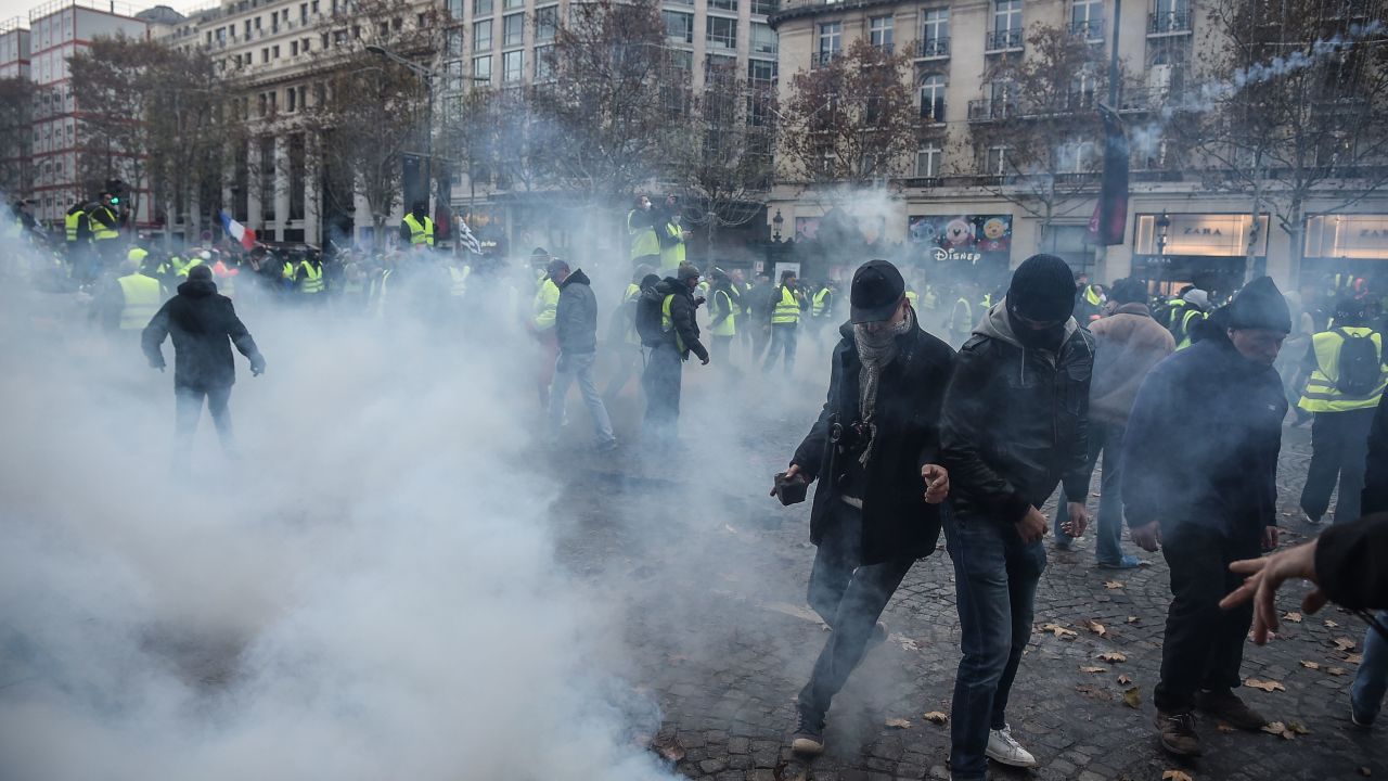 Protesters clash with riot police who fired tear gas canisters Saturday in central Paris.