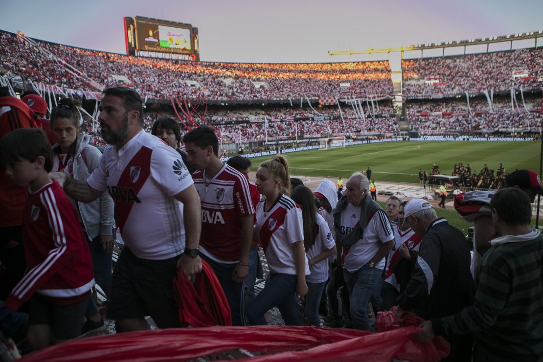 Fans of River Plate leave the stadium after the game was delayed multiple times and eventually postponed for Sunday.