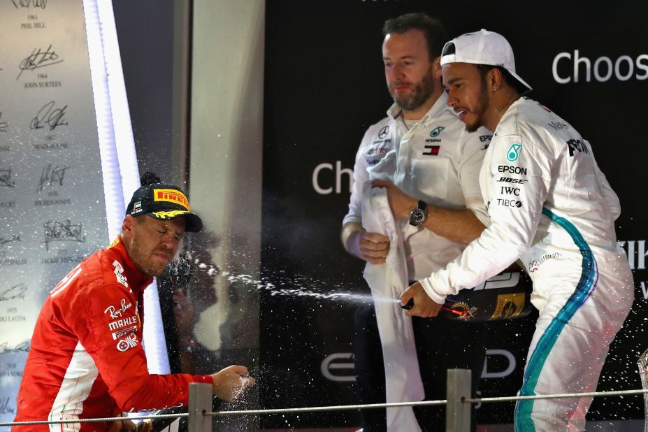 Lewis Hamilton sprays second-placed Sebastian Vettel with champagne after winning the Abu Dhabi season-ending race, 11th of his title winning season.