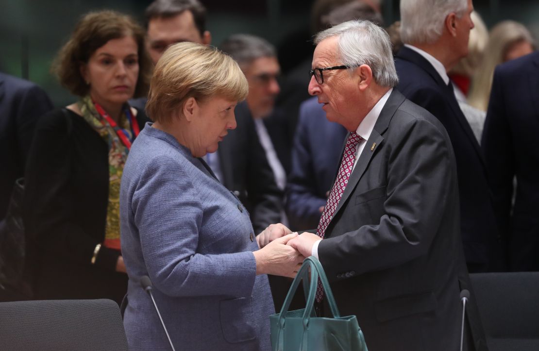 German Chancellor Angela Merkel and European Commission President Jean-Claude Juncker greet each other in Brussels on Sunday.