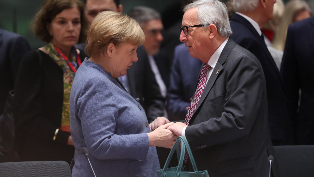 German Chancellor Angela Merkel and European Commission President Jean-Claude Juncker greet each other in Brussels on Sunday.