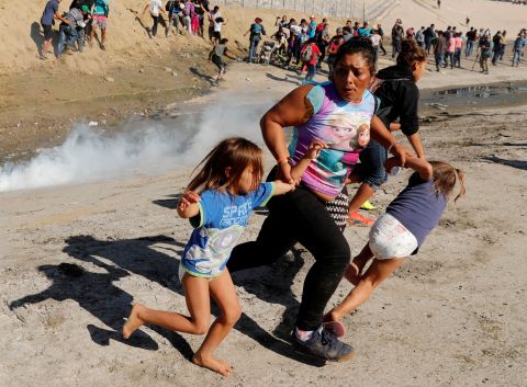 A migrant family from Honduras runs from tear gas that was deployed by US Border Patrol agents near the fence between Mexico and the United States.