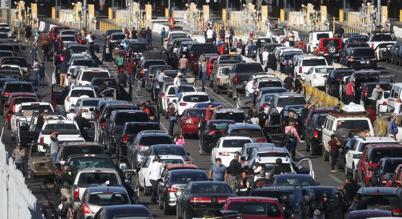 People attempting to cross into the United States gather near their vehicles after the San Ysidro Port of Entry was closed because of the migrant unrest.