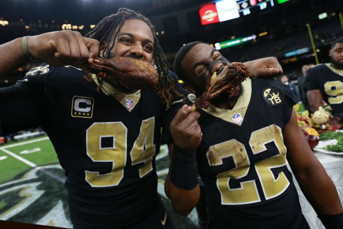 Cameron Jordan and Mark Ingram of the New Orleans Saints eat turkey after a game against the Atlanta Falcons on Thursday, November 22 in New Orleans, Louisiana. The Saints defeated the Falcons 31-17.