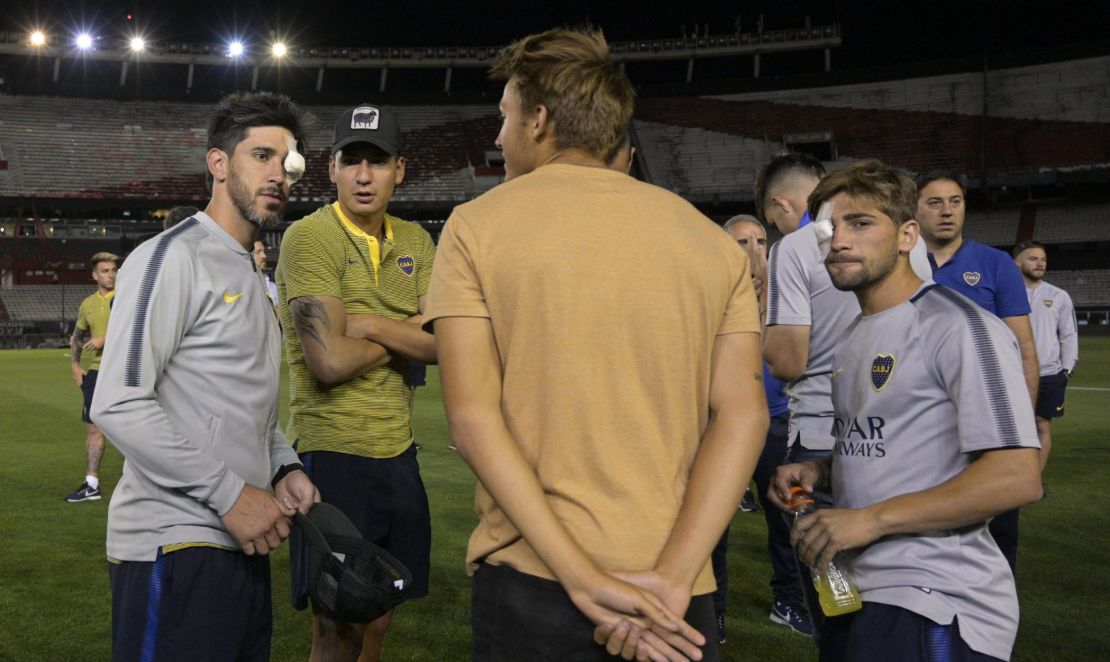 Boca Juniors' Pablo Perez and Gonzalo Lamardo are seen on the field of the Monumental stadium in Buenos Aires with their eyes covered after authorities postponed the all-Argentine Copa Libertadores final.