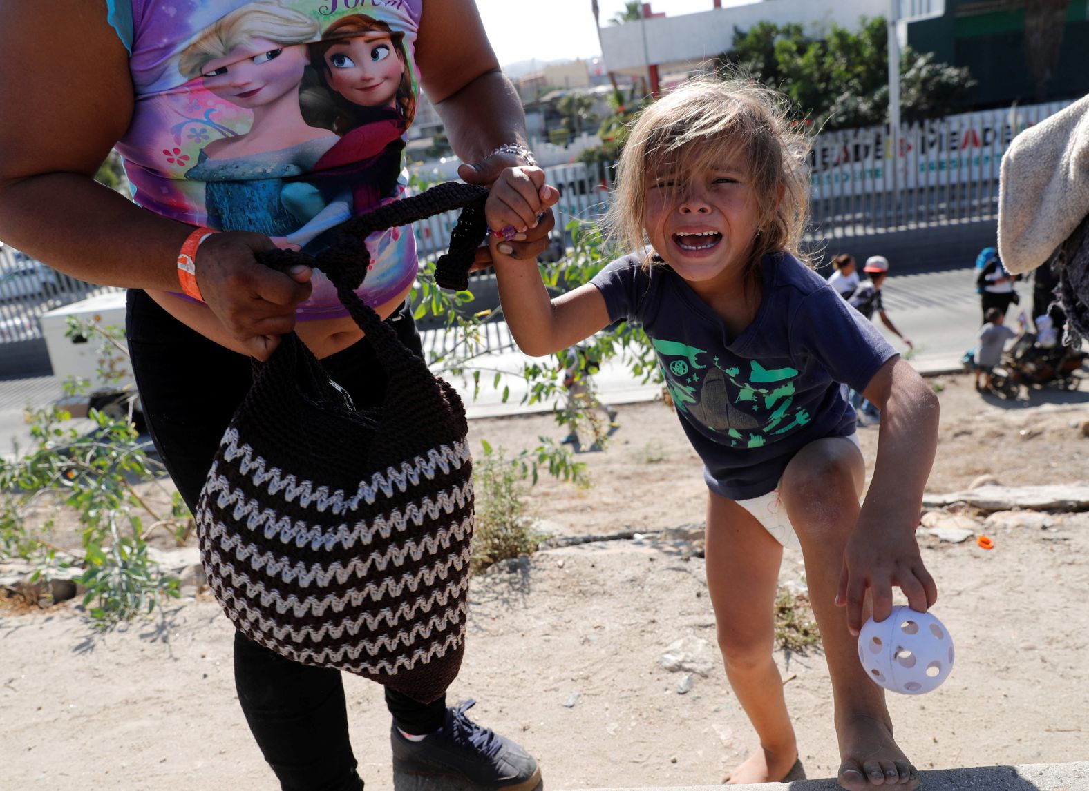 A migrant girl from Honduras cries after running away from tear gas on November 25. Her mother told Reuters she was trying to bring her children to the US to reunite them with their father in Louisiana.