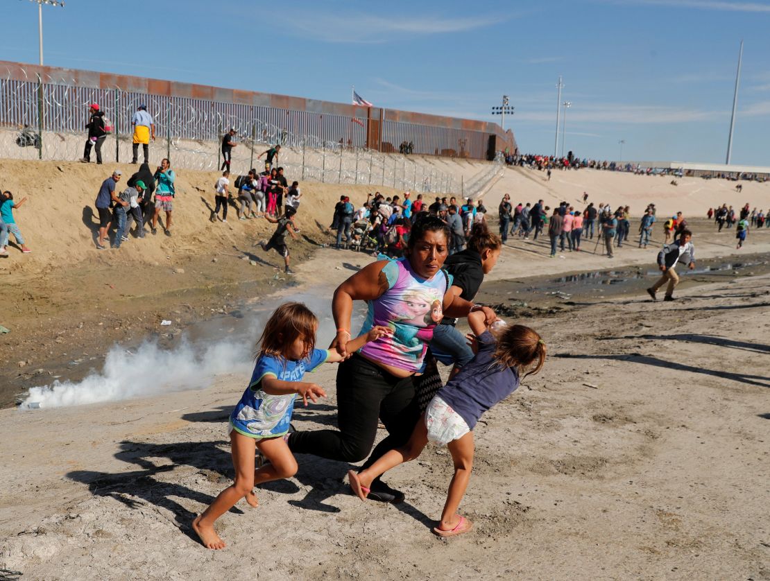 A Honduran mother and children run away from tear gas November 25 in Tijuana, Mexico.